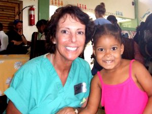 Judy Gura, RN, with a child in a La Romana orphanage. Photo by Brenda Bazyluk.